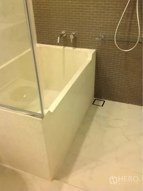 Condominium for rent or sale in Watthana, Bangkok - Modern bathroom with deep soaking tub, handheld shower and tiled wall