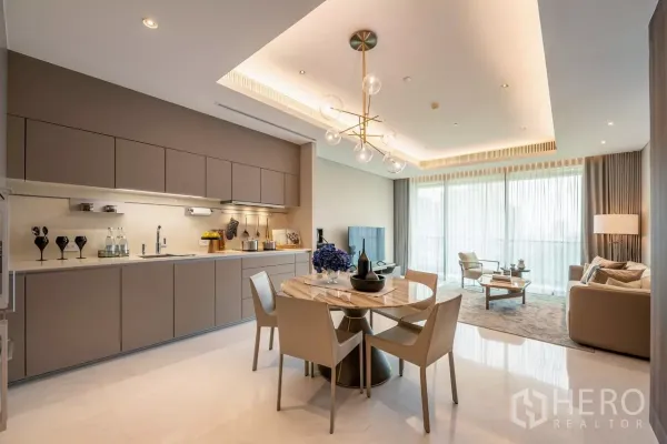 Condominium for rent or sale in Pathum Wan, Bangkok - Open-plan kitchen, dining and lounge with modern chandelier and full-height sheer curtains.