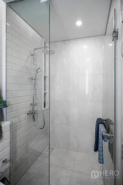คอนโด ขายในKhlong Toei, Bangkok - ห้องอาบน้ำทันสมัย ฉากกั้นกระจก ฝักบัวเรนชาวเวอร์ และผนังกระเบื้องโทนขาว