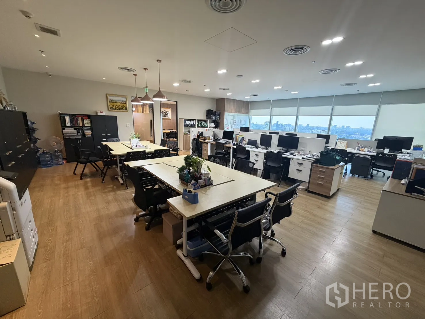 Office Space for rent in Khlong Toei, Bangkok - Spacious open office with multiple workstations, storage cabinets, wood floors, and panoramic city views.