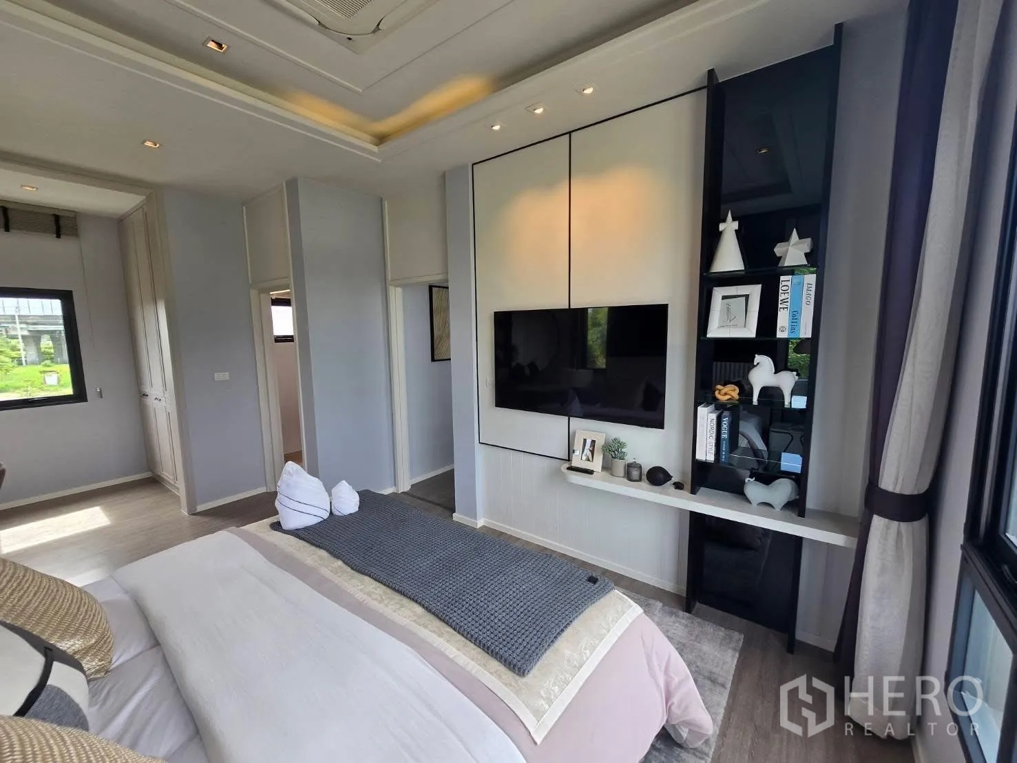 Semi-detached House for rent in Bang Phli, Samut Prakan - Bedroom wall with built-in TV unit and shelving opposite the bed.