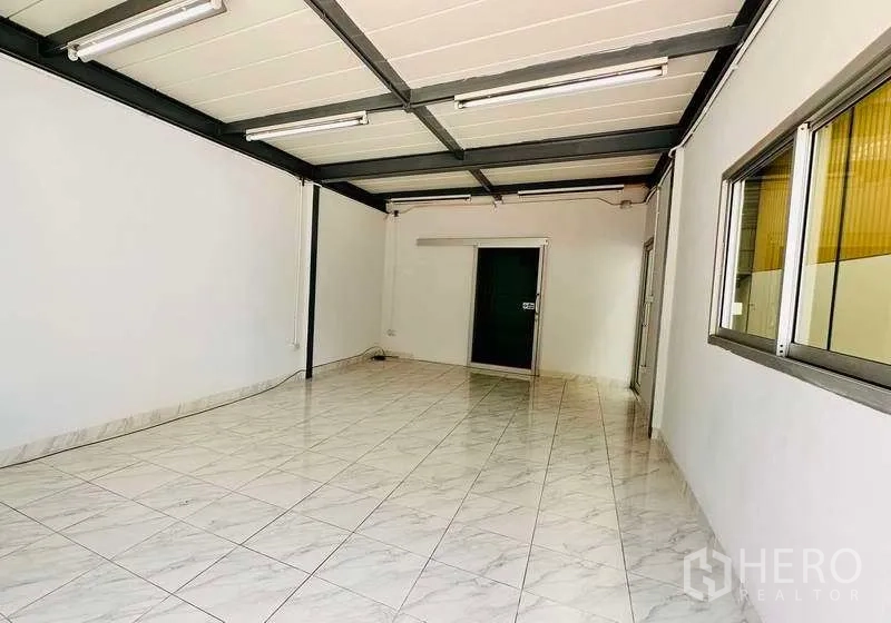 Warehouse for rent in Pak Kret, Nonthaburi - Tiled office room inside the warehouse with windows and exposed steel beams.