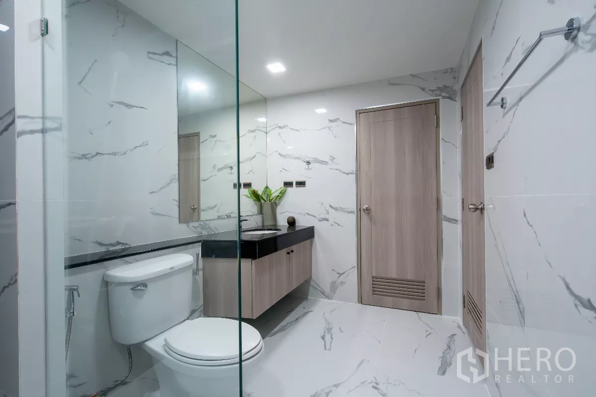 Apartment for rent - Bathroom with marble-effect tiles, floating vanity and a large mirror.