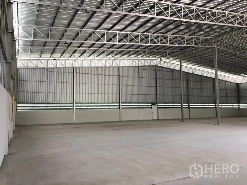Warehouse for rent in Lat Lum Kaeo, Pathum Thani - Open storage hall showing steel columns and natural light panels.