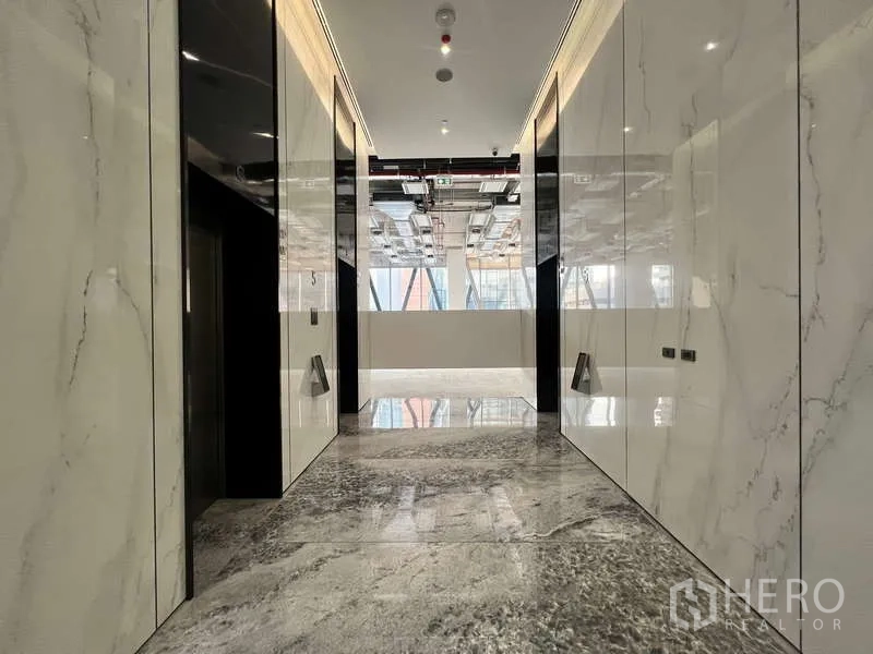 办公空间 出租 - 大理石装饰的电梯大堂，抛光地面与现代灯光，位于高端写字楼内