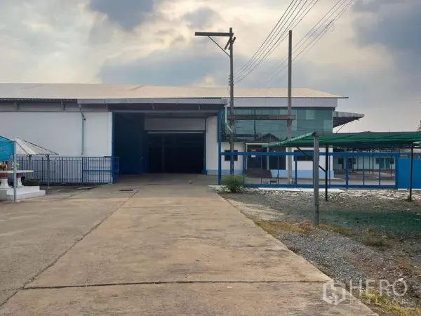 คลังสินค้า ให้เช่าในNong Khaem, Bangkok - มุมมองจากถนนสู่โครงการโกดัง พร้อมอาคารสำนักงานกระจกและประตูรั้ว