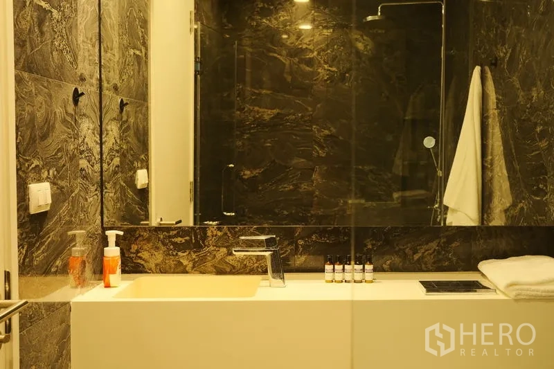 公寓 出租在Bang Rak, Bangkok - 现代卫浴，仿石材墙面，宽大洗手台与玻璃淋浴间