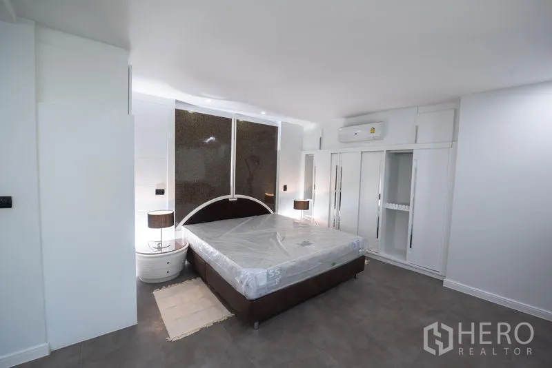 คอนโด ให้เช่าในKhlong Toei, Bangkok - ห้องนอนใหญ่เตียงคิงไซส์ ตู้เสื้อผ้าบิวท์อิน โต๊ะหัวเตียง และผนังไฮไลต์