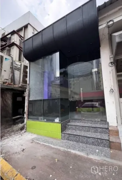 พื้นที่ขายปลีก ให้เช่าในWatthana, Bangkok - ด้านหน้าร้านกระจกเต็มมุม มีกันสาดสีดำและบันไดหินขัด