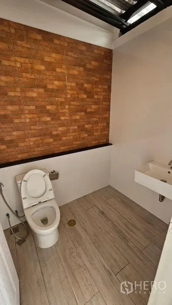 สำนักงานที่บ้าน ให้เช่าในBang Na, Bangkok - ห้องน้ำแขก ผนังแต่งลายอิฐ โถสุขภัณฑ์และอ่างล้างหน้า