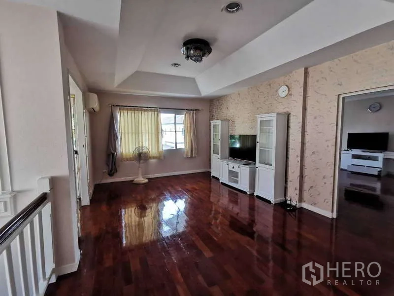 บ้าน ให้เช่า - ห้องนั่งเล่นชั้นบน พื้นไม้ขัดเงา ตู้ทีวี โคมไฟเพดาน และทางเชื่อมไปยังห้องนอน