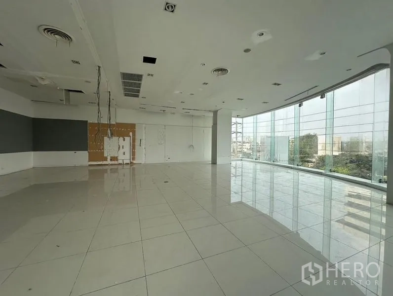 零售空间 出租在Din Daeng, Bangkok - 转角展厅，环绕落地玻璃与光亮地砖，机电预留完善。