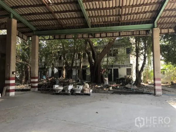 คลังสินค้า ให้เช่าในThanyaburi, Pathum Thani - ลานขนถ่ายสินค้าแบบมีหลังคา เปิดออกสู่ลานที่มีต้นไม้ใหญ่และอาคารเตี้ย