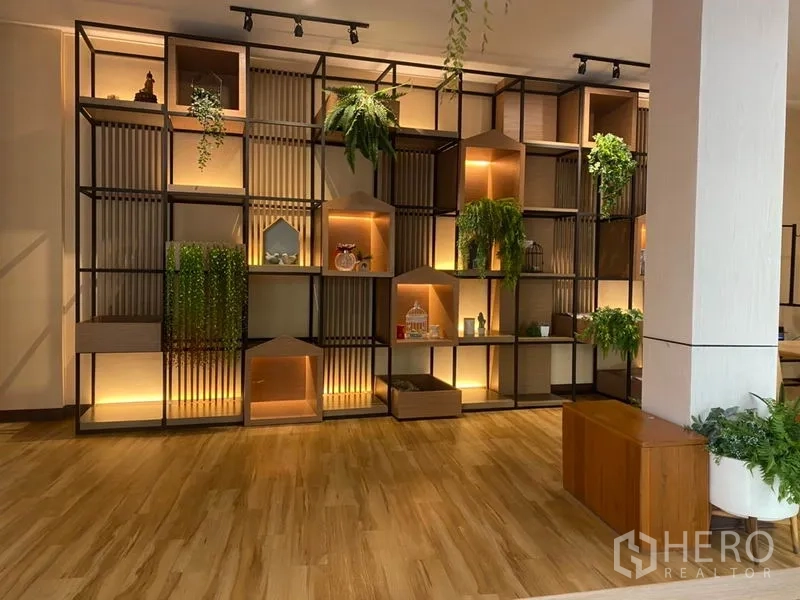 零售空间 出租在Khlong Toei, Bangkok - 整面带灯模块化展示墙，配绿植与摆件，木地板零售空间。