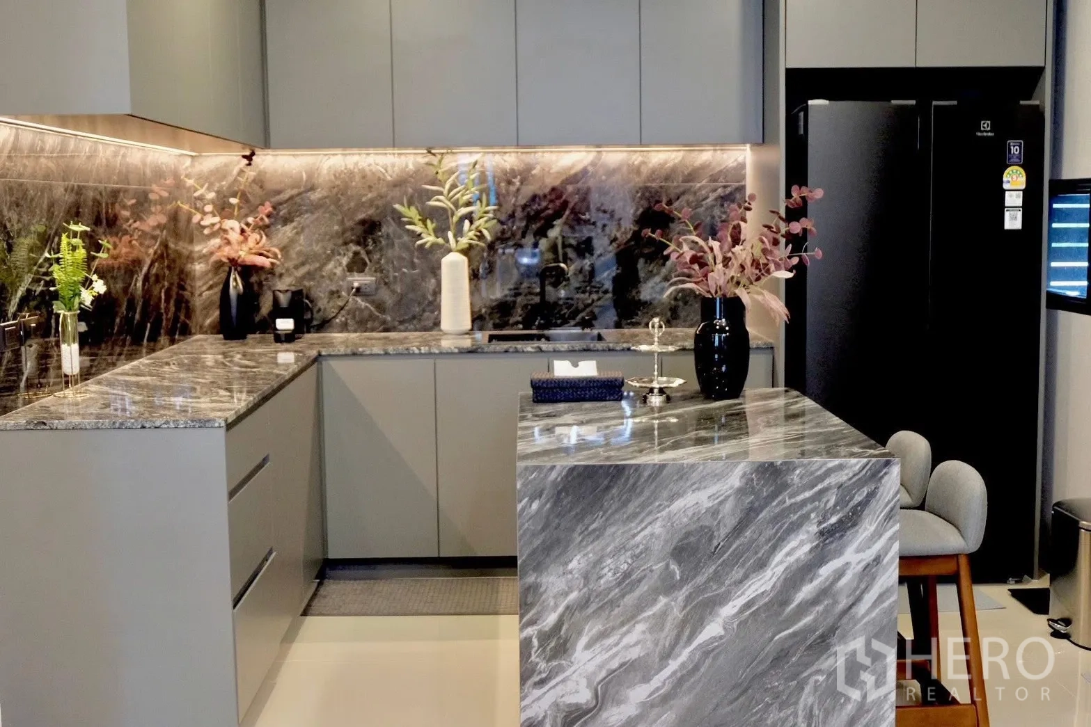 Semi-detached House for sale in Prawet, Bangkok - U-shaped kitchen with stone countertops, backsplash and black fridge.