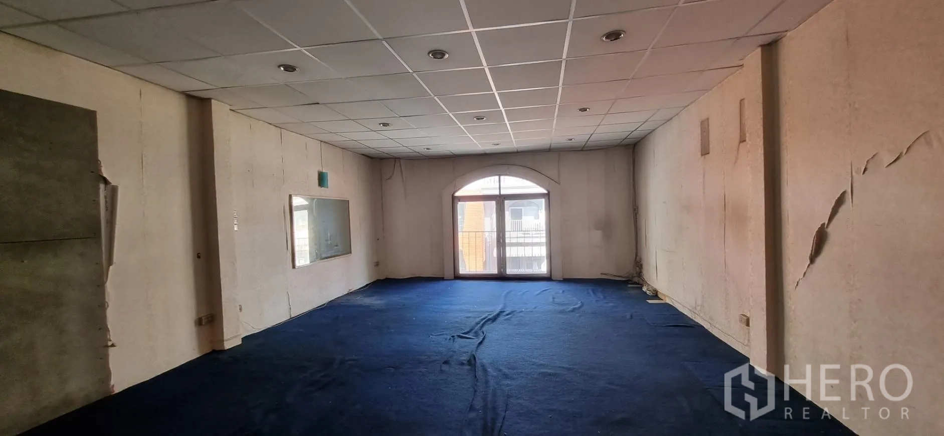 店屋 出租或出售在Bangkok - 宽敞的楼上房间，吊顶、蓝色地毯与拱形阳台门。