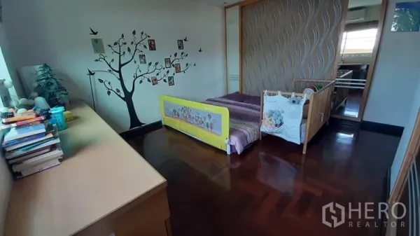 คอนโด ให้เช่าในWatthana, Bangkok - ห้องนอนอบอุ่น มีเตียงเด็ก ผนังลายต้นไม้ พื้นไม้ และตู้บิลท์อินข้างหน้าต่าง