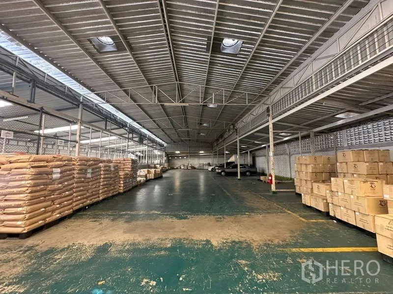 คลังสินค้า ให้เช่าในYan Nawa, Bangkok - โกดังขนาดใหญ่เพดานโครงทรัสโลหะ พื้นที่ทำงานโล่ง มีเส้นตีสีและกล่องวางบนพาเลต