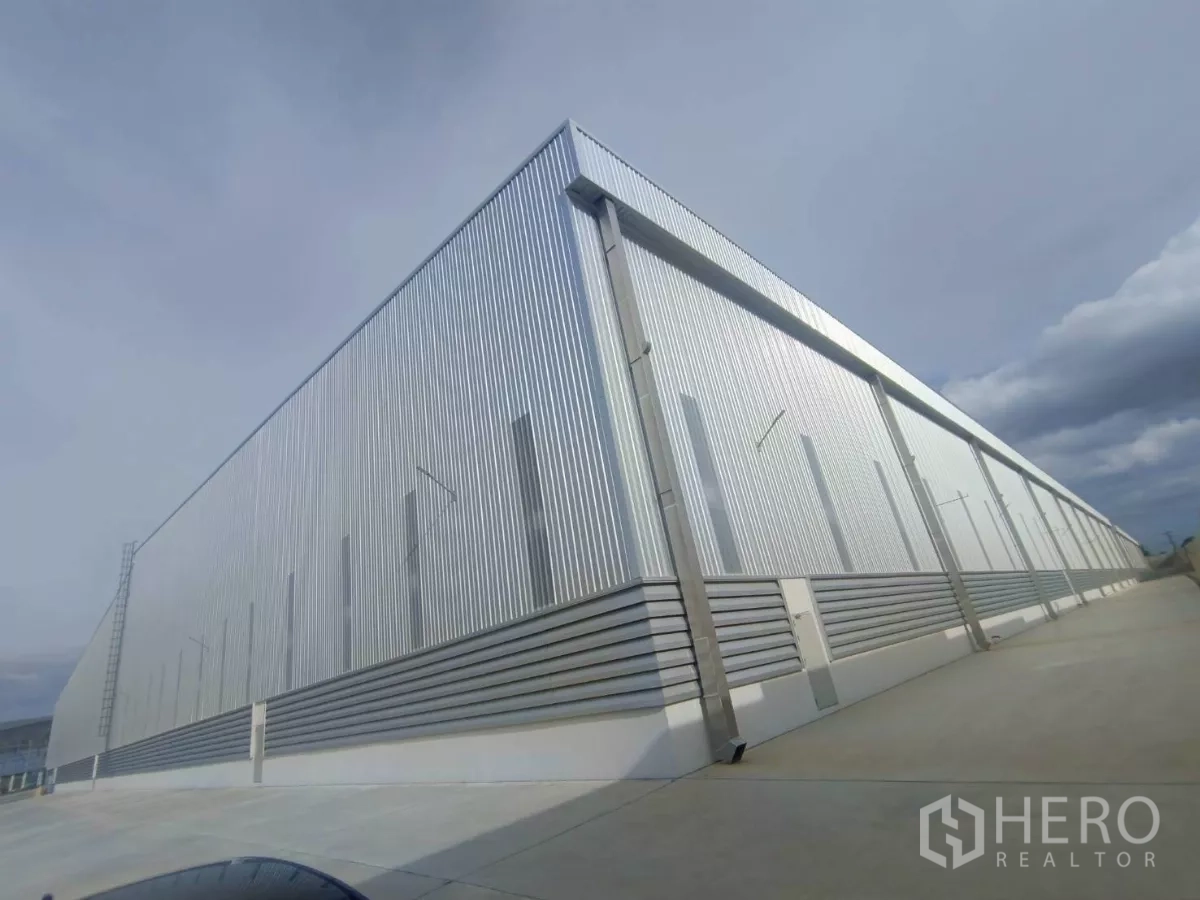 Factory for rent in Si Racha, Chon Buri - Rear elevation of corrugated metal-clad factory with clean concrete apron.