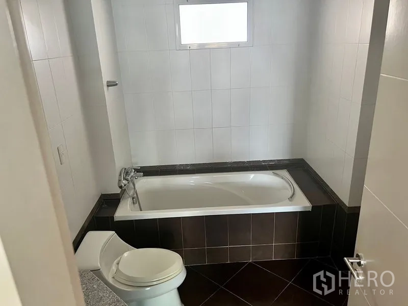 คอนโด ให้เช่าในBang Kho Laem, Bangkok - ห้องน้ำพร้อมอ่างอาบน้ำ กำแพงกระเบื้องสีขาว มีหน้าต่างบานเล็ก และพื้นกระเบื้องสีเข้ม