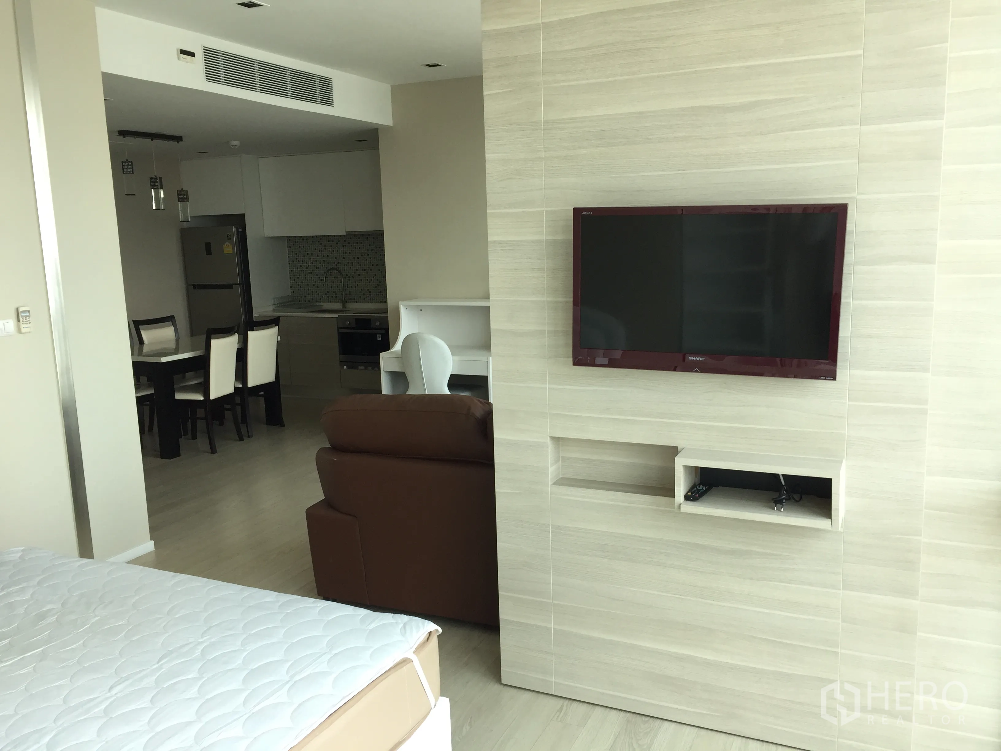 公寓 出租在Watthana, Bangkok - 卧室对面的内嵌式电视墙，连接开放式厨房与餐区。