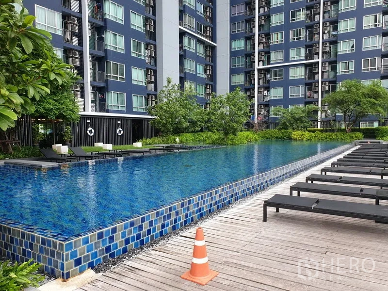 Condominium for rent in Watthana, Bangkok - Outdoor swimming pool with sun deck beside the condominium building.