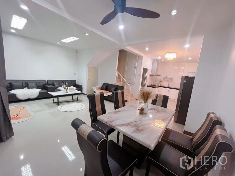 ทาวน์เฮาส์ ให้เช่าในHuai Khwang, Bangkok - โถงนั่งเล่น–ทานอาหารกว้าง โต๊ะหินอ่อน พัดลมเพดาน และวิวเชื่อมครัว