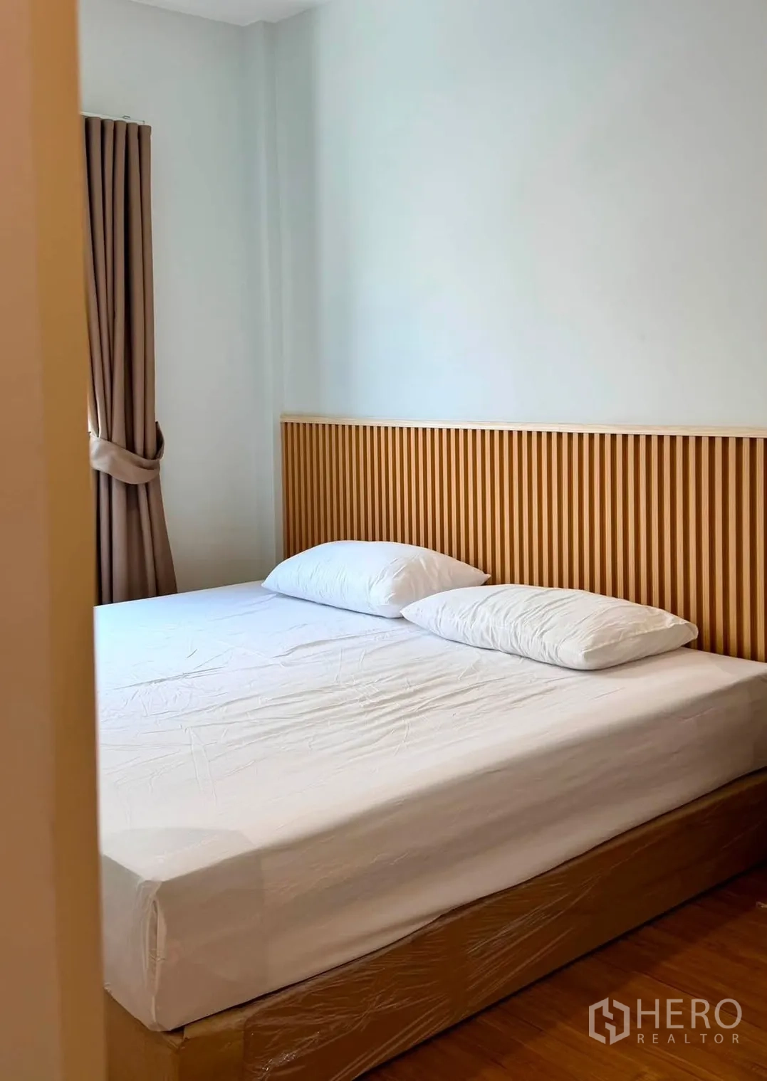 Townhouse for rent in Bang Phli, Samut Prakan - Cozy bedroom with a double bed, slatted wood headboard, and curtains.