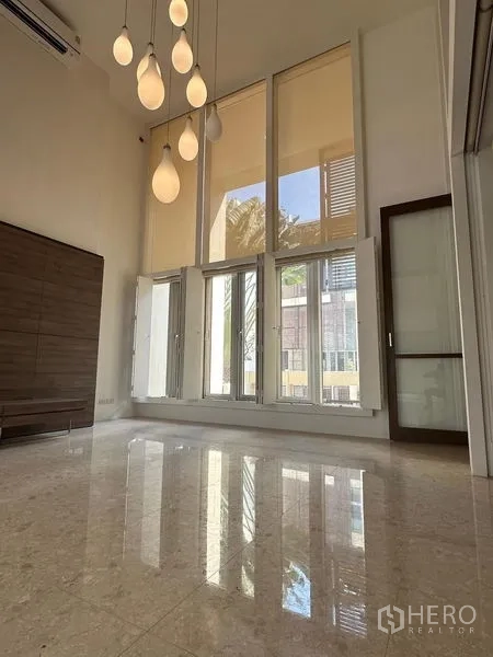 ทาวน์เฮาส์ ขายในYan Nawa, Bangkok - ห้องนั่งเล่นเพดานสูงโปร่ง กระจกเต็มผนังและโคมไฟแขวนแบบคลัสเตอร์