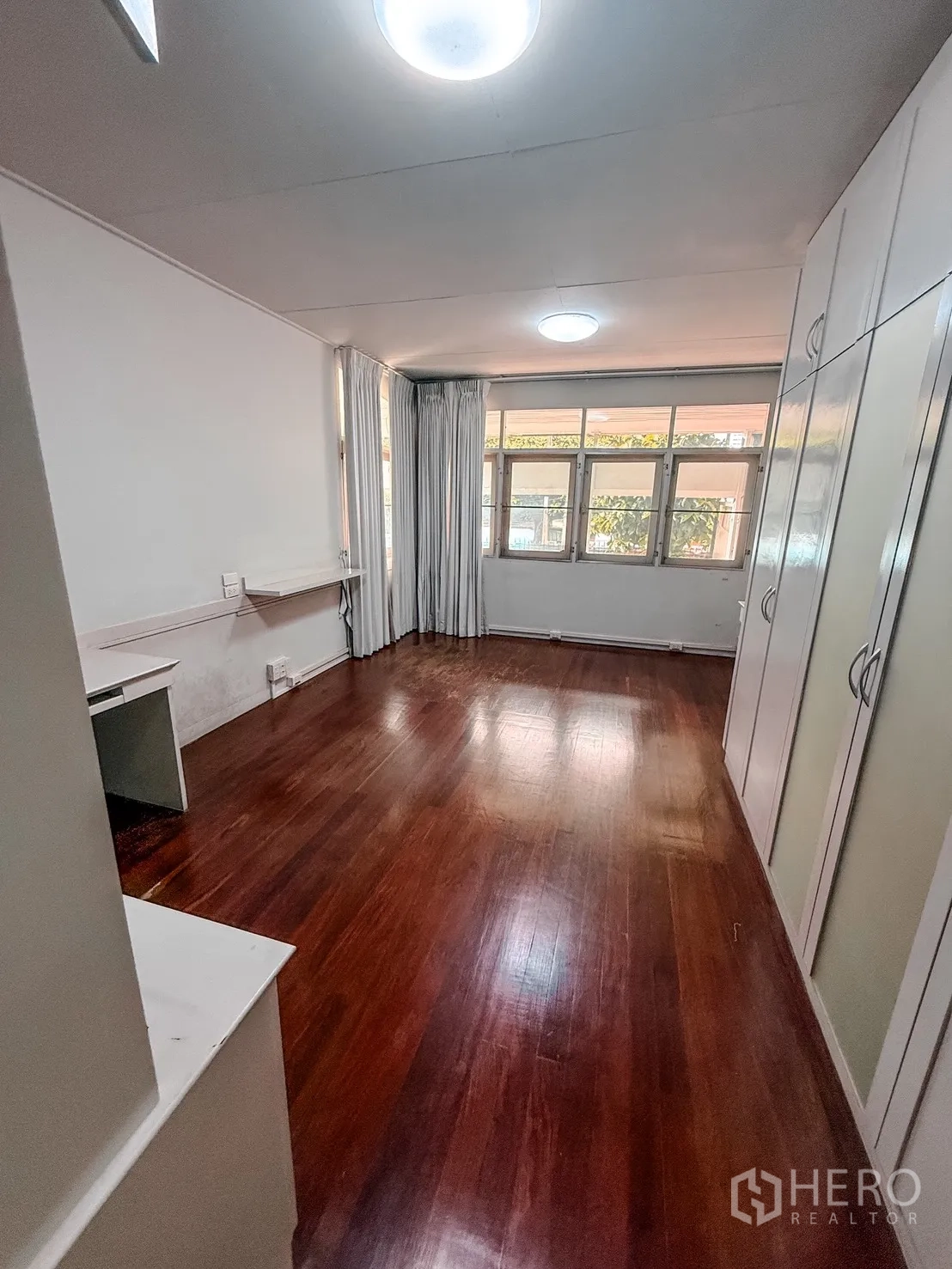 家庭办公室 for rent in Watthana, Bangkok - 长形房间，木地板，大窗配窗帘，带内置衣柜与书桌。