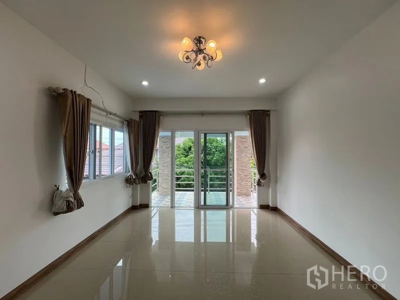 บ้าน ขายในMin Buri, Bangkok - ห้องนั่งเล่นเปิดสู่ระเบียง ประตูกระจกบานเลื่อนและโคมไฟ