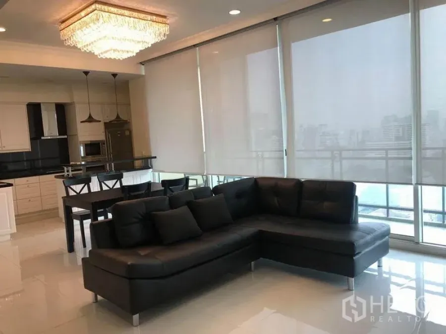 คอนโด ให้เช่าในWatthana, Bangkok - ห้องนั่งเล่น โซฟาหนังสีดำ ไฟแขวน และประตูบานเลื่อนกระจกสูงจดเพดาน