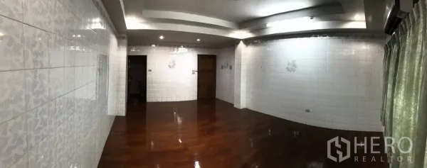 Home Office for rent in Dusit, Bangkok - Large interior room with polished hardwood floors, white tiled walls, and recessed lighting.