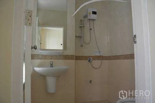 Home Office for rent in Wang Thonglang, Bangkok - Bright bathroom with pedestal sink, mirror and shower with water heater in a Bangkok home office.