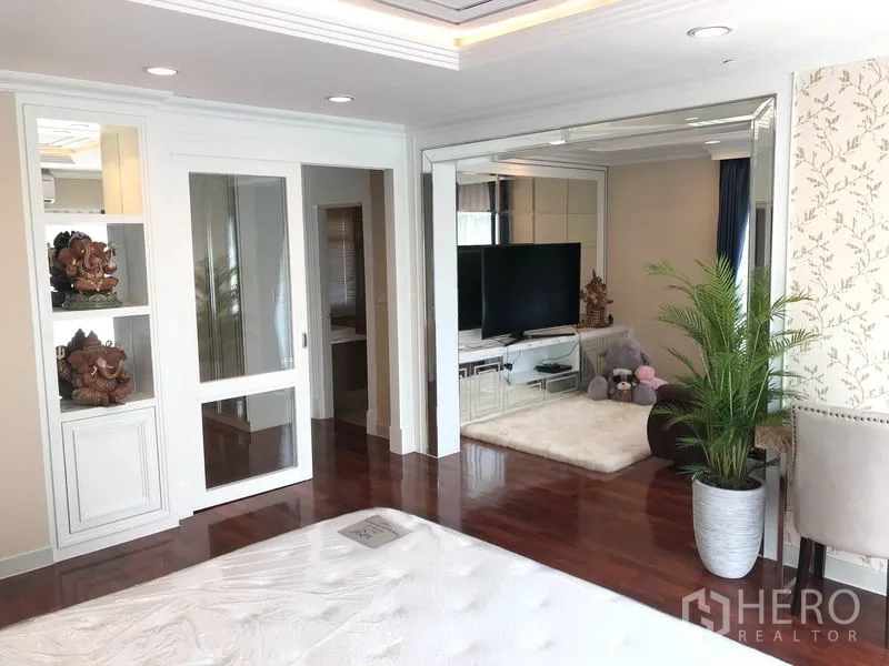 Detached House for rent or sale in Saphan Sung, Bangkok - Spacious bedroom with mirrored wall, sliding doors, and potted plant decor.