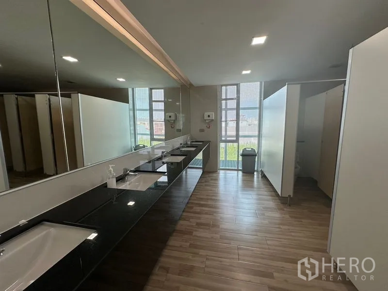 Office Space for rent - Spacious restroom with long vanity, multiple sinks, and toilet stalls.