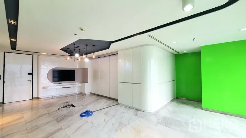 办公空间 出租在Watthana, Bangkok - 等候/休闲区，电视背景墙、吊灯、亮面地板与绿色特色墙。