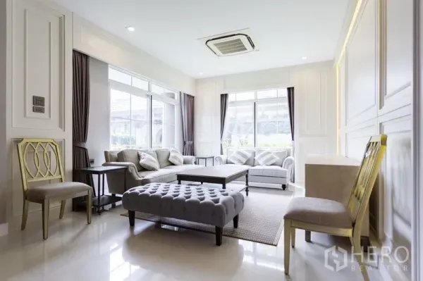 独立式住宅 出租在Mueang Samut Prakan, Samut Prakan - 采光充足的客厅，大窗、成套沙发与吊顶风管空调。