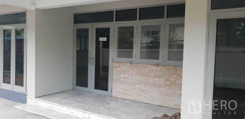 带办公室的家 出租在Chatuchak, Bangkok - 入口门廊配玻璃门窗，旁有石材装饰墙面。