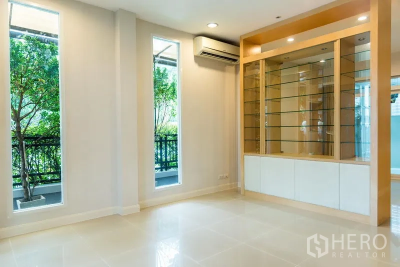 ทาวน์เฮาส์ ขายในWang Thonglang, Bangkok - ห้องนั่งเล่นอีกมุมพร้อมตู้โชว์บิวท์อินและหน้าต่างสูงมองเห็นต้นไม้