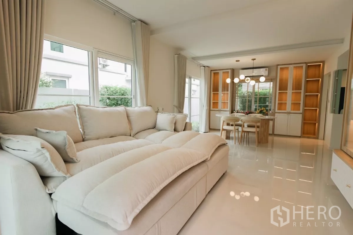 独立式住宅 出租或出售在Bang Phli, Samut Prakan - 开放式客厅连接餐区，亮面地砖与定制柜体。