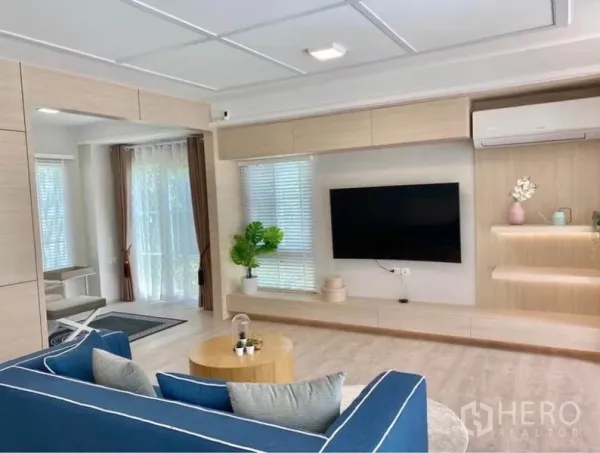 联排别墅 出租在Prawet, Bangkok - 采光充足的客厅，电视墙与悬空柜、落地窗