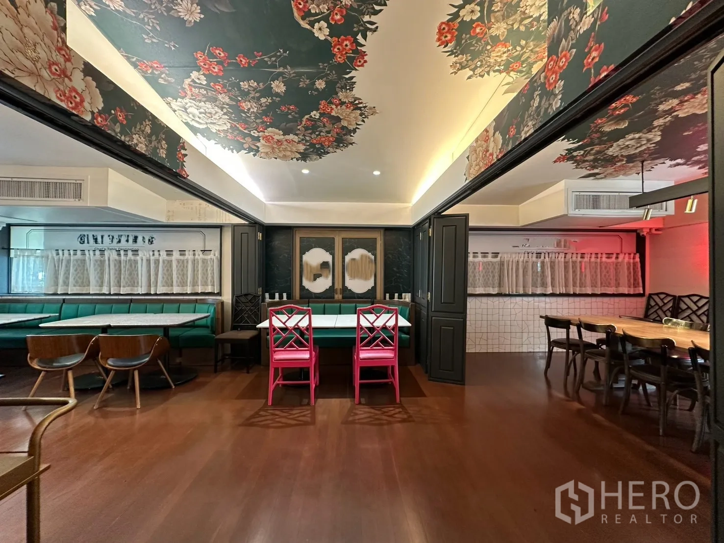 Detached House for rent in Watthana, Bangkok - Open dining room with floral ceiling, green banquettes, and wood floors.