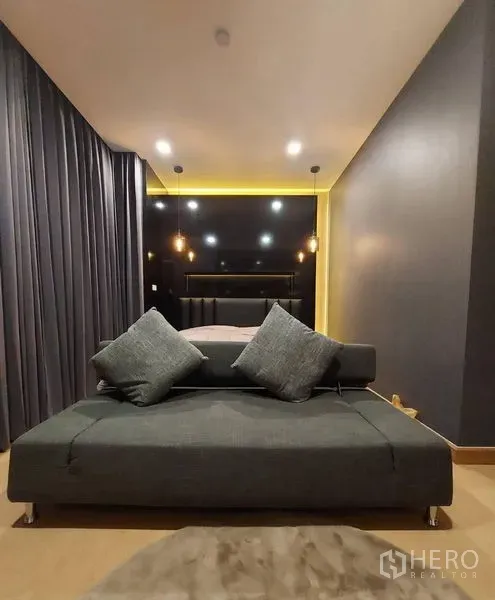 联排别墅 出租在Thanyaburi, Pathum Thani - 卧室带深色强调墙、吊灯与床尾灰色沙发