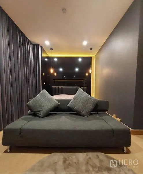 联排别墅 出租在Thanyaburi, Pathum Thani - 卧室带深色强调墙、吊灯与床尾灰色沙发