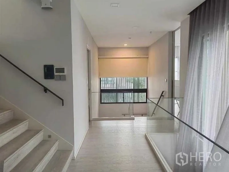 บ้าน ให้เช่า - โถงชั้นบนพร้อมบันได ราวกันตกกระจก และช่องแสงขนาดใหญ่.