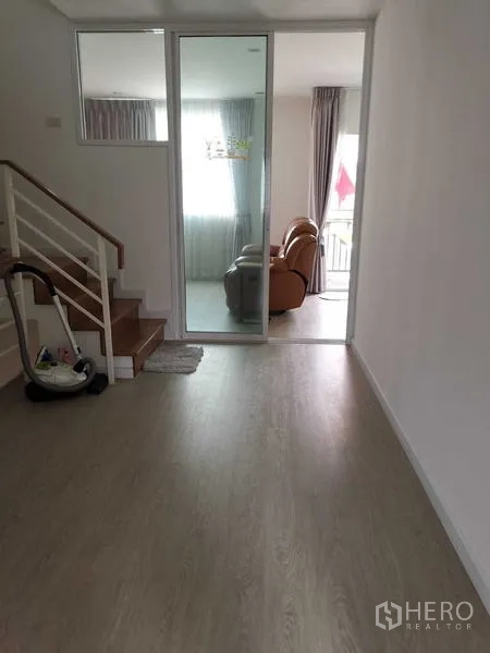 Home Office for rent or sale - Upper-floor hall with staircase and glass sliding door leading to a lounge.