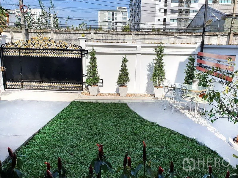 บ้าน ให้เช่าในPhra Khanong, Bangkok - สวนหน้าบ้านสนามหญ้า กระถางต้นไม้ ประตูรั้วลายทอง และชุดโต๊ะเก้าอี้กลางแจ้ง