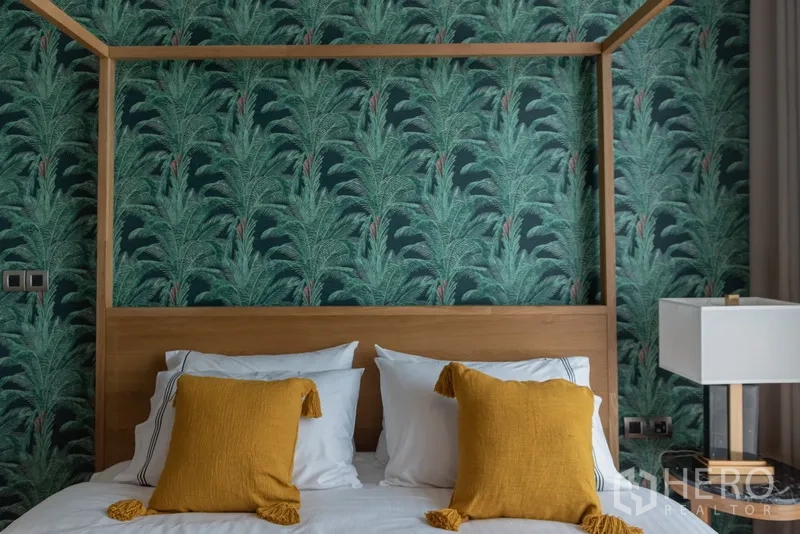 คอนโด ขายในWatthana, Bangkok - ห้องนอนเตียงโครงไม้ ผนังลายทรอปิคัล และหมอนสีเหลืองมัสตาร์ด