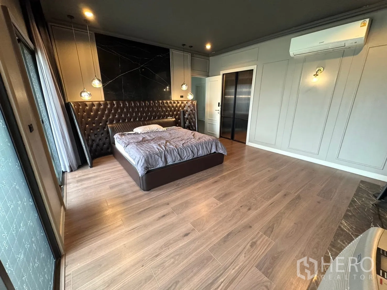 独立式住宅 出售在Mueang Pathum Thani, Pathum Thani - 主卧，软包床头、阳台门与空调。